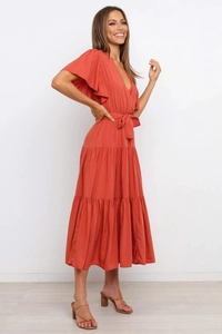 Detalle de la falda con volantes escalonados y la cintura ajustada en este vestido caramelo en V