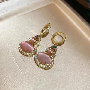 Macro shot of 14k gold-plated gourd earrings with pink stones and sparkling zircons