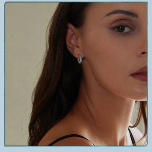 Detail of blue and white enamel wavy hoop earrings in s925 silver on model's ear