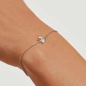 Close-up of a silver bee bracelet with cubic zirconia wings on a woman's wrist