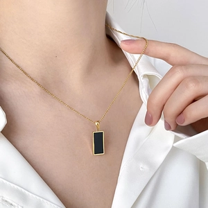 Minimalist double-layered gold chain necklace featuring geometric black agate square pendant