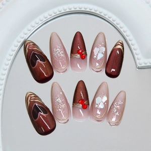 Dark red cat eye press-on nails with 3D crystal hearts and pearls on long almond tips
