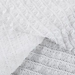 Detail of white hollow textured fabric with delicate mesh structure and lace pattern