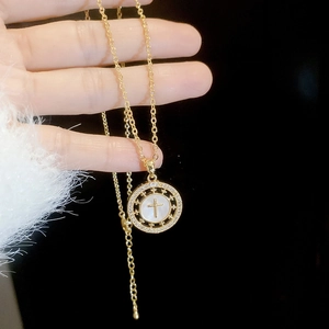 Gros plan détaillé du collier croix plaqué or 18 carats avec nacre et zircons brillants