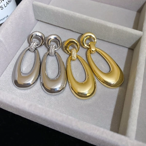 Detail of gold and silver teardrop hoop earrings with micro-inlaid cubic zirconia crystals