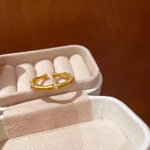 Detail of a vintage golden bamboo ring with sparkling zircons on a beige velvet box