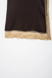 Close-up of silk-textured brown fabric with intricate beige lace trim detail