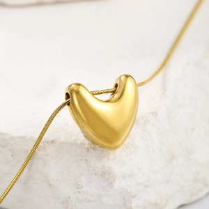 Macro shot of gold-plated 3D heart pendant necklace with sleek snake chain detail
