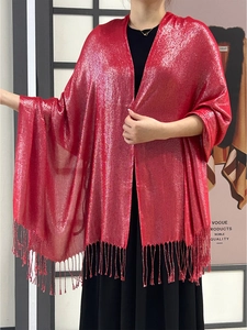 Close-up of red shimmering shawl with metallic silver threads and elegant fringe tassels