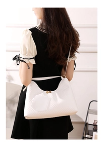 Detailed back view of white quilted tote bag with V-pattern and gold hardware