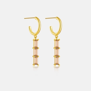 Detail of gold drop earrings featuring rectangular amber stones with high-quality polished finish