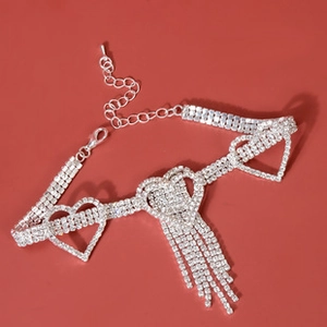 Detailed view of silver heart rhinestone collar with long fringe on a red background