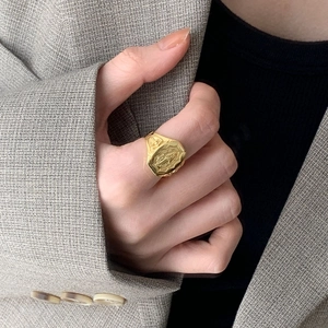 Macro detail of gold S925 silver ring featuring vintage portrait engraving on hand
