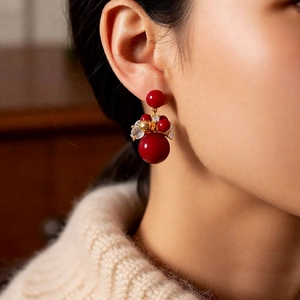 Detail of red cluster bead earrings with gold accents and sparkling micro-inlaid rhinestones