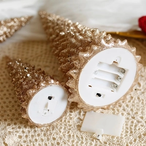 Golden glitter mini Christmas tree lights showing battery compartment and power switch