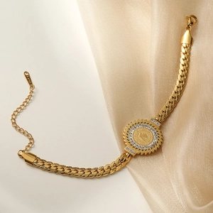 Elegant gold Cuban chain bracelet with a sparkling coin pendant and silk texture background