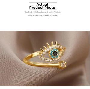 Close-up of golden Evil Eye open ring with blue and white zircons on velvet