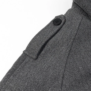 Close-up of grey wool jacket shoulder with epaulet detail and black button fastener