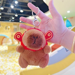 Close-up of a brown plush capybara keychain with red cloud detail and silver lobster clasp