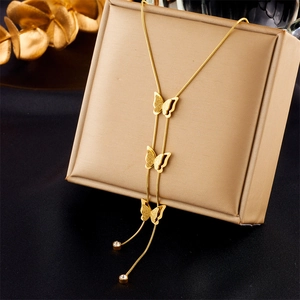 Close-up of golden butterfly fringe necklace with rhinestone details on a jewelry box