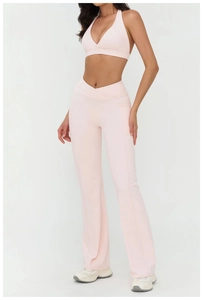 Pink sports set with halter bra and cross waist flared leggings featuring side pockets