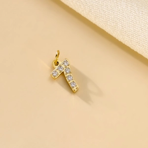 Macro view of gold number 7 pendant with micro-pave cubic zirconia on soft fabric