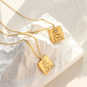 18K gold plated titanium necklace with Egyptian solar relief pendant on white rock