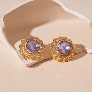 Close-up of gold chain-link stud earrings with purple crystal in a luxury setting