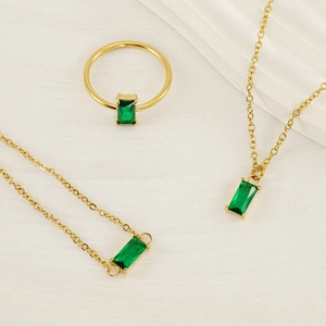 Detail of 18K gold-plated stainless steel jewelry set with emerald green rectangular stones