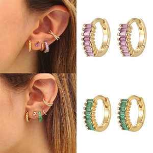 Detail view of 925 silver huggie earrings with purple and green baguette cut cubic zirconia