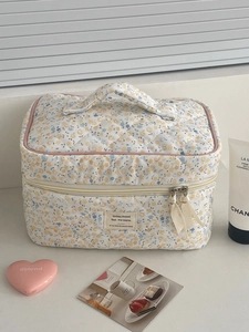 Détail de la trousse de maquillage fleurie en velours avec texture matelassée et rubans