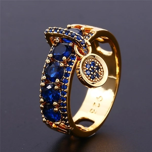 Detailed macro view of gold plated 925 silver ring with blue zircons and round charm