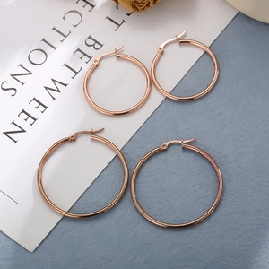 Detail of two pairs of rose gold stainless steel hoop earrings in different sizes