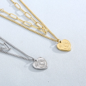 Macro view of gold and silver layered necklaces featuring a spinning heart pendant