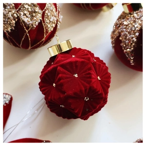 Close-up of a burgundy velvet Christmas ball ornament with sparkling gold sequins