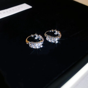 Macro shot of silver wheat-shaped hoop earrings with sparkling leaf-cut zircons