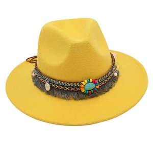 Dettaglio della fascia etnica con pietra turchese e frange su un cappello fedora giallo