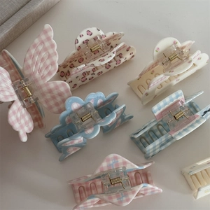 Flat lay of floral and checkered bow claw clips with golden metal springs
