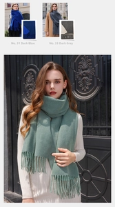 Detail shot of solid color thick cashmere-feel scarf with long tassels in dark blue