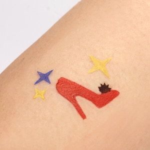 Halloween body art tattoo stencil featuring a red high heel and stars on arm skin