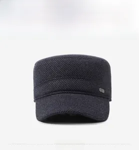 Detail view of dark grey flat top cap showing wool blend texture and metal emblem