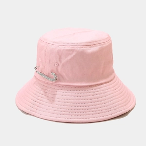 Detailed view of pink cotton bucket hat featuring a rhinestone safety pin accent