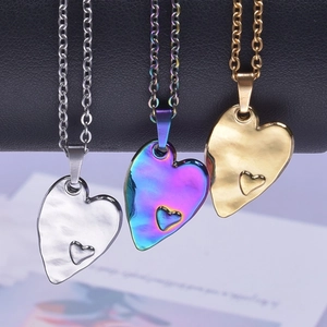 Three heart pendant necklaces in silver, gold, and iridescent finishes on metal chains