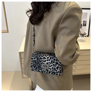 Close-up of leopard print crossbody bag with metallic chain and stud detailing