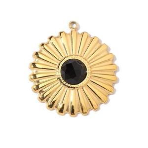 Detailed view of a golden sunburst pendant with a black gemstone inlay and top bail