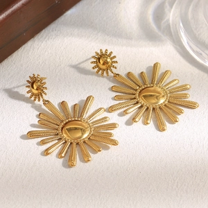Detailed view of 18K gold plated stainless steel sunflower pendant earrings on white surface