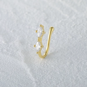 Detail of S925 silver nose cuff with gold finish and two marquise-cut clear zircons