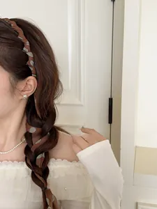 Detail of French vintage brown polka dot chiffon scrunchie braided into a low ponytail
