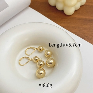 Detailed view of French gold triple sphere drop earrings with length measurements
