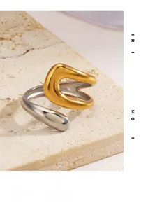 Detail of minimalist two-tone gold and silver open ring on textured stone